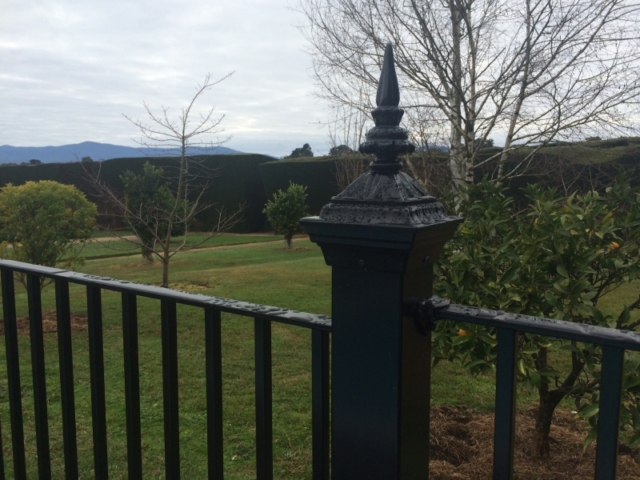 Black wrought iron fence and post top