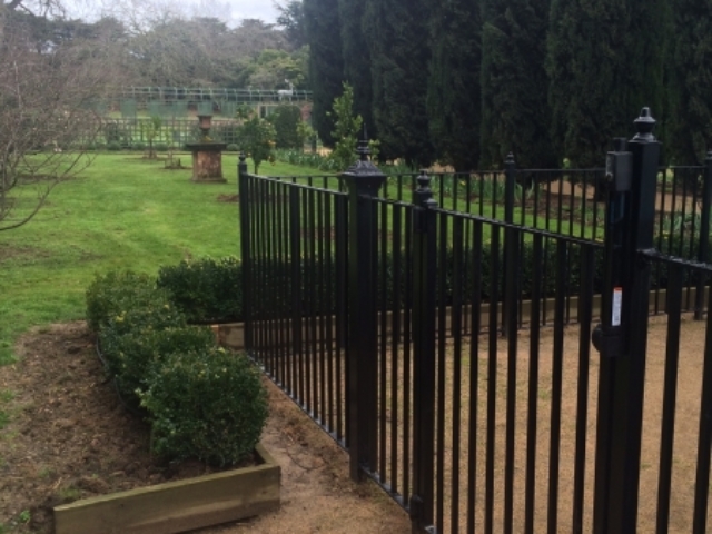 Black wrought iron fence and pedestrian gate