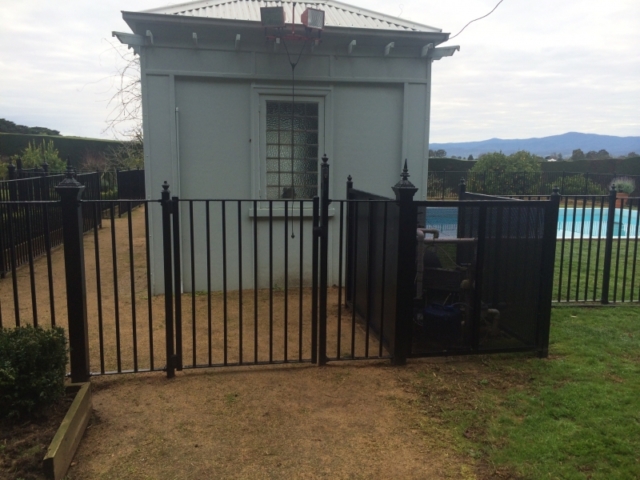 Black wrought iron pool fence and pedestrian gate