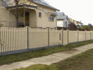 Cream steel picket fence with grey posts and bottom rail