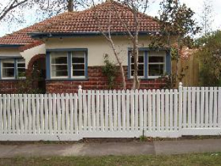 White steel picket fence with white posts and bottom rail